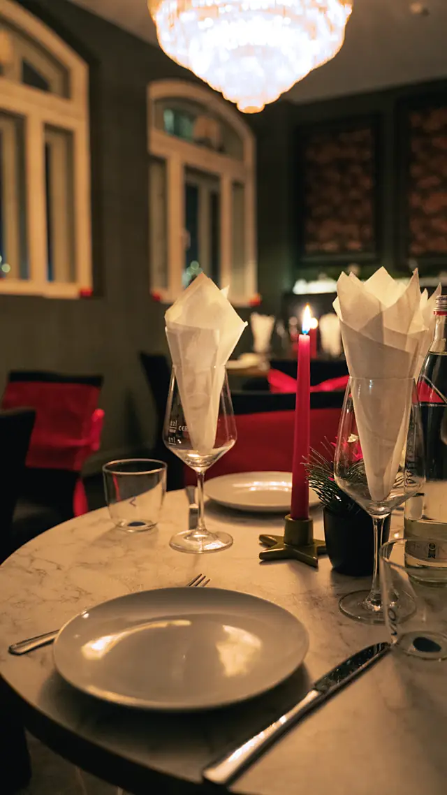 Gedeckter Tisch mit Kerzen unter dem Kronleuchter
