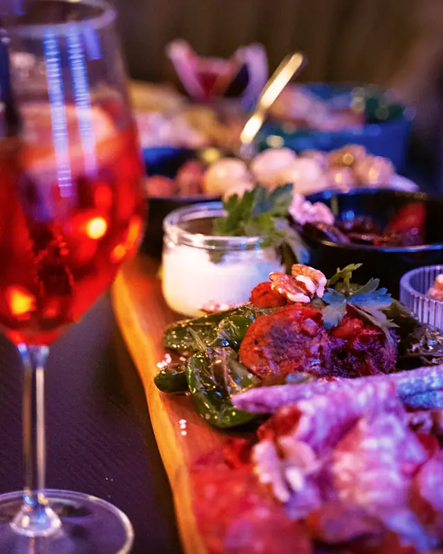 Aperitif im Glas neben einer angerichteten Tapasplatte