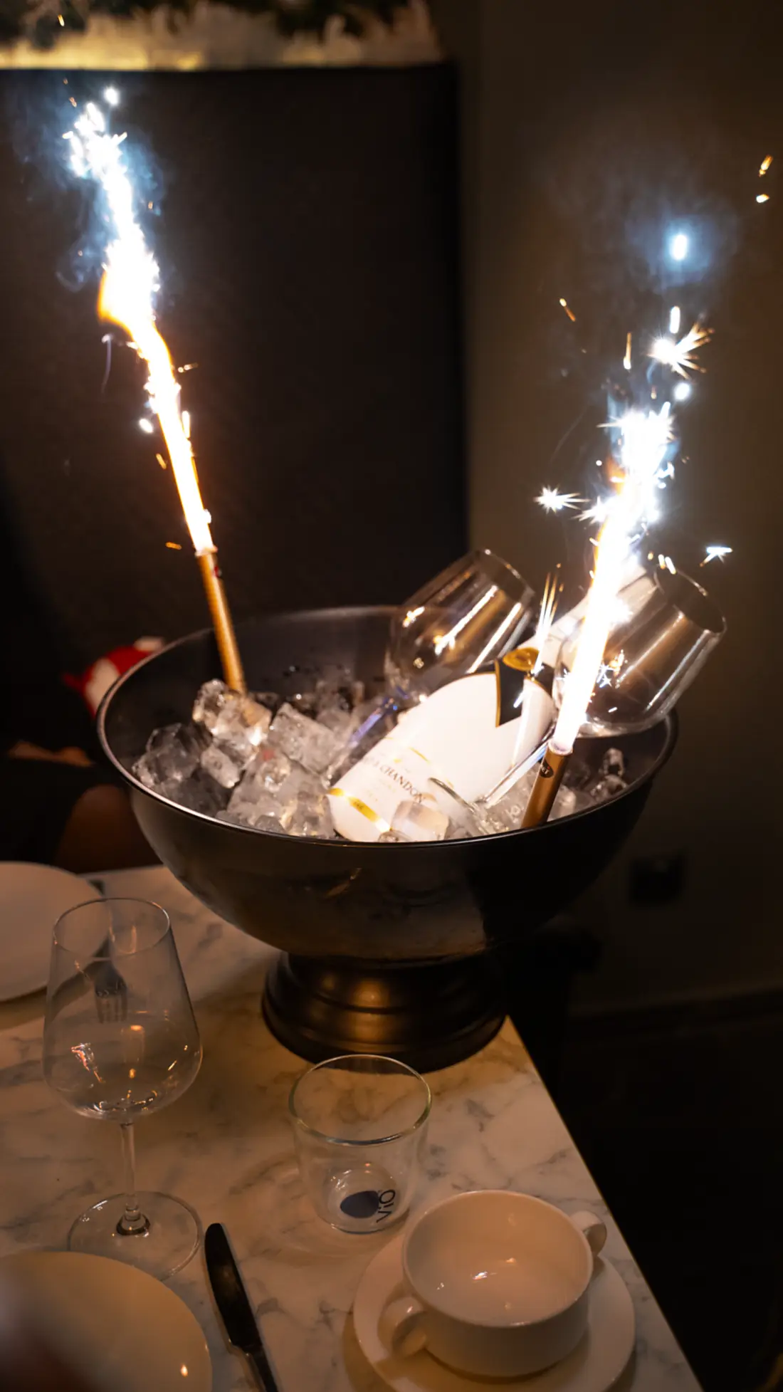 Champagnerkühler mit Wunderkerzen auf dem Tisch