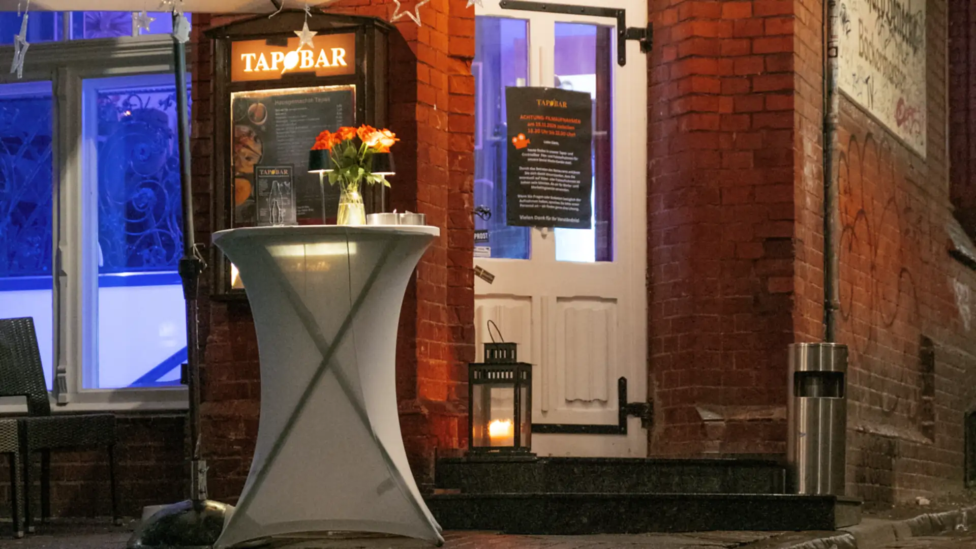 Der beleuchtete Eingang der Tap Bar am Stintmarkt in Lüneburg bei Nacht